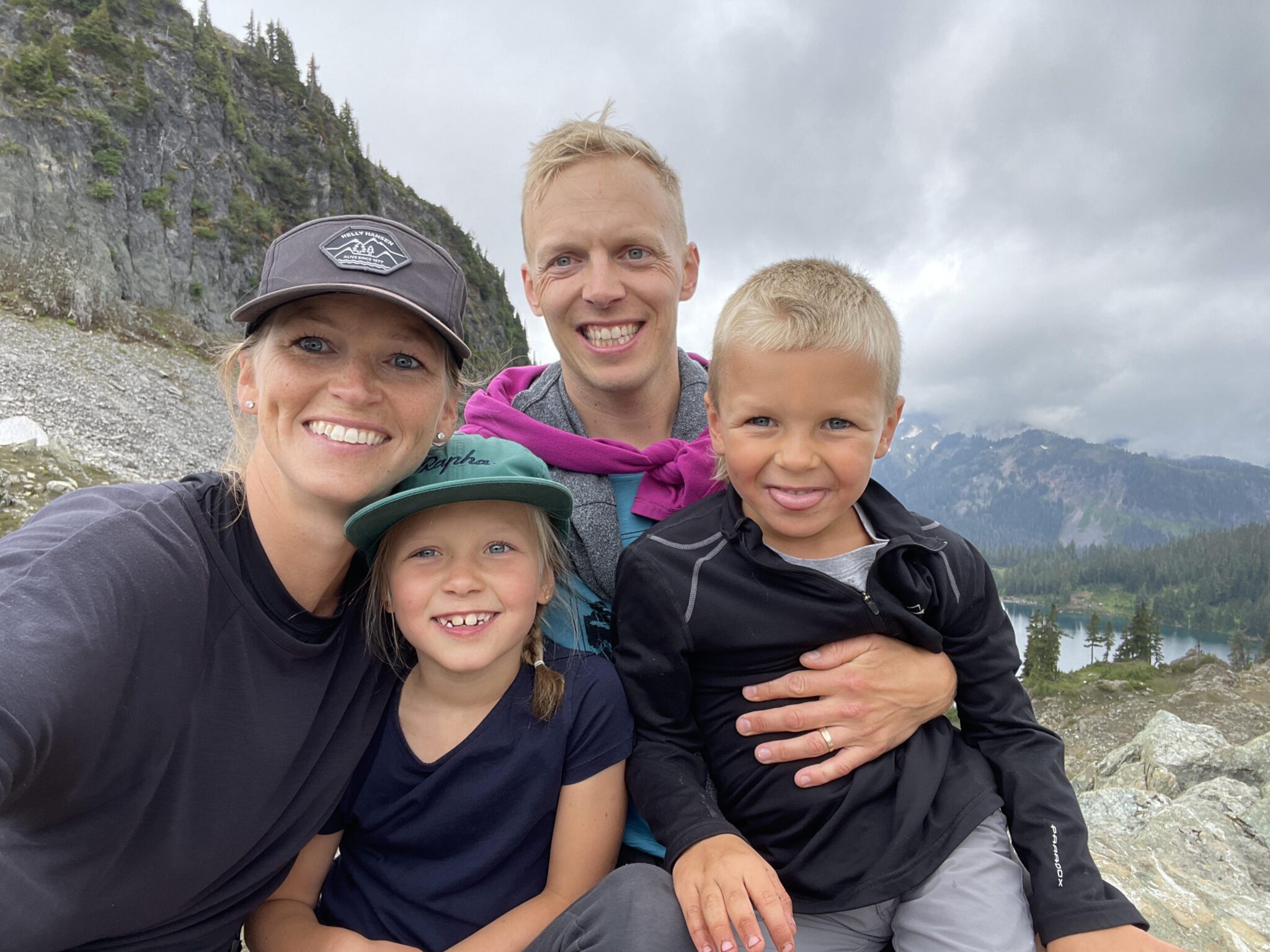 A photo of David, his wife, and three children posing with a mountain in the distance.